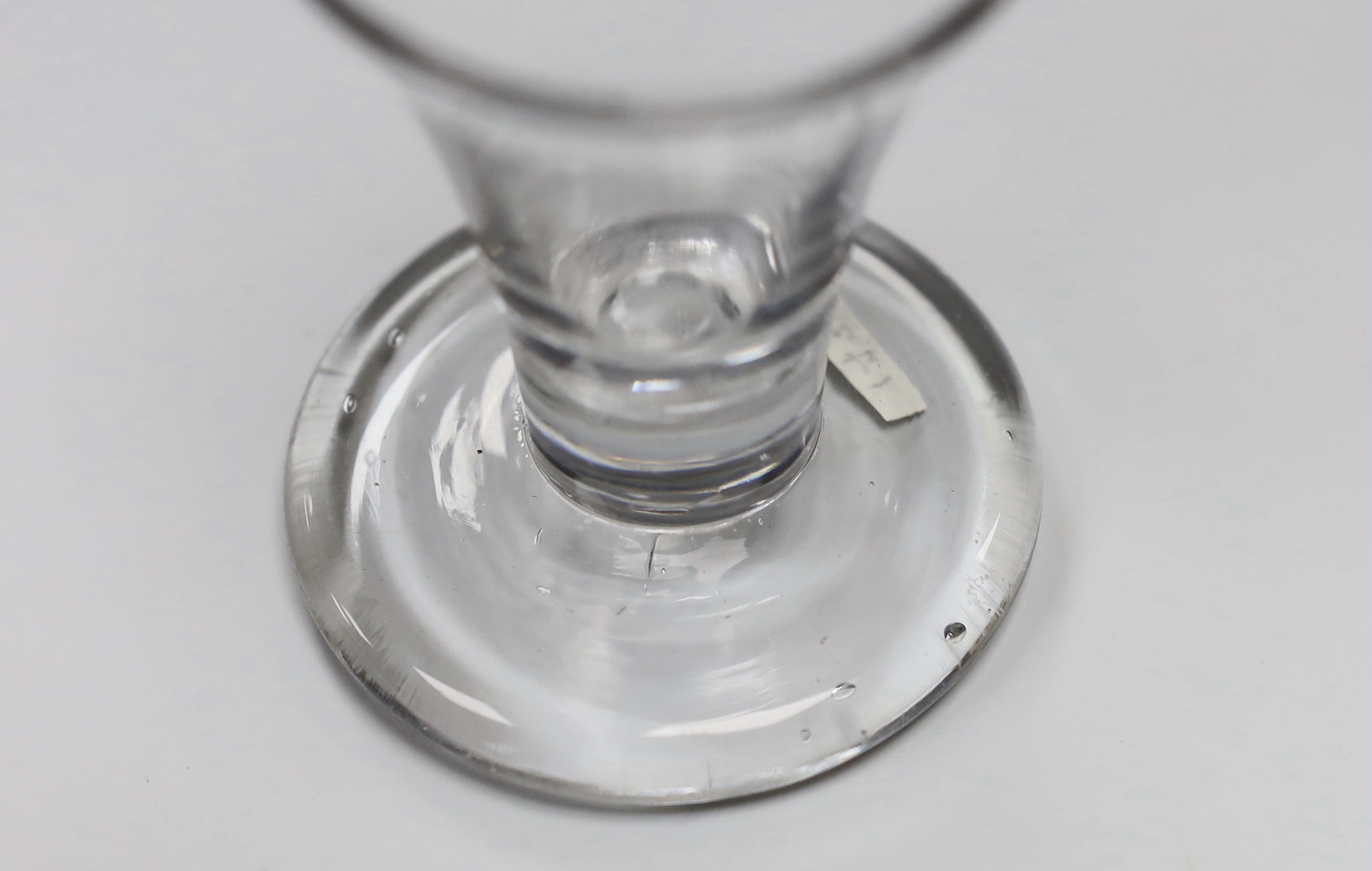 An English lead crystal drawn trumpet dram, c.1750, with striations and tool marks on a wide, heavy foot, 9.3cm high